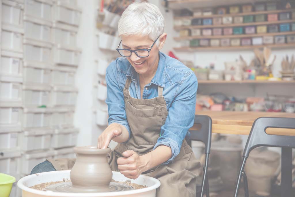 Mature woman creating pots.